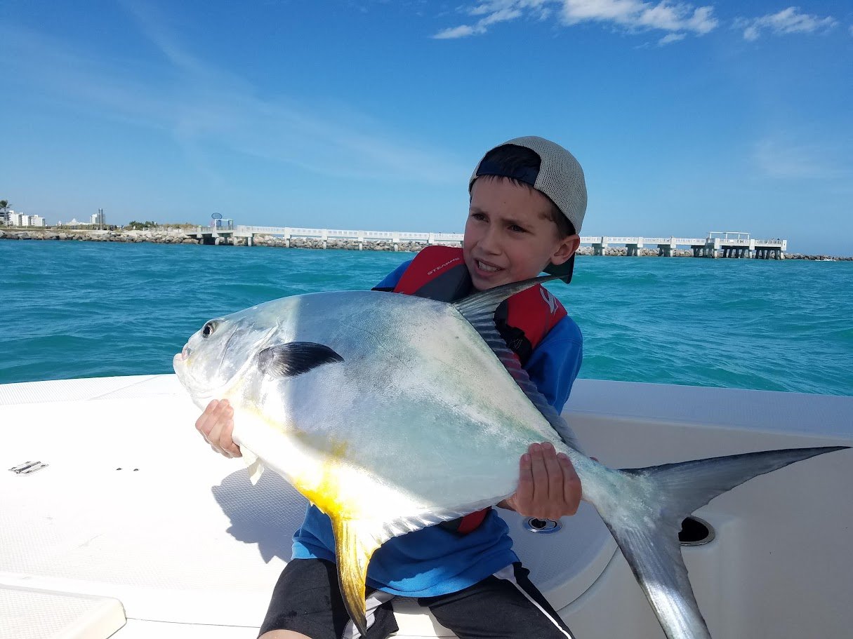Young angler with a trophy permit